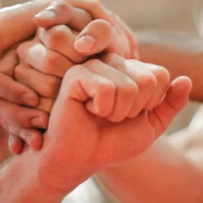 Teamwork in action as multiple hands come together in a unified gesture, symbolising collaboration and support among team members.