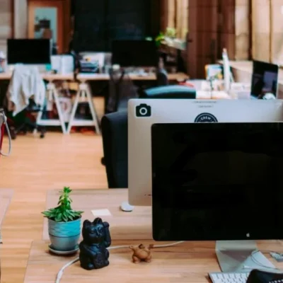 Spacious, eclectic office space with a variety of workstations and personal touches, illustrating a dynamic and creative work environment.