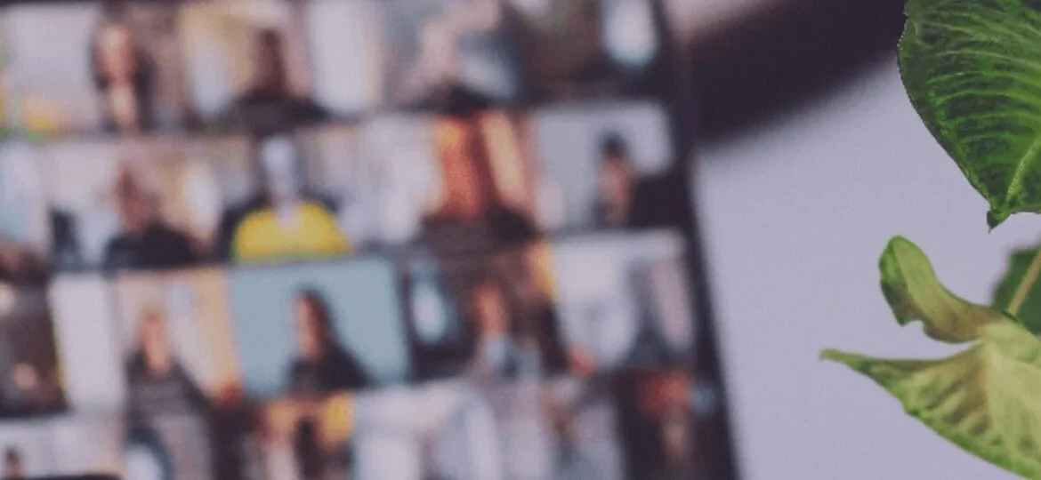 Blurred background of a laptop screen displaying a virtual meeting with multiple participants, symbolizing remote collaboration.