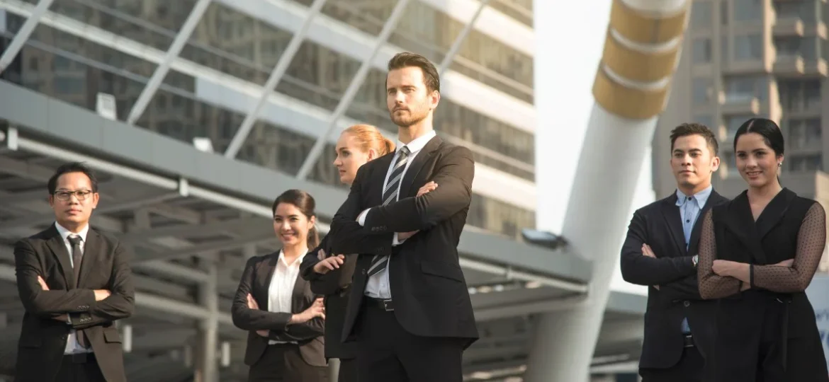 A group of diverse business leaders demonstrating transformational leadership in a modern urban setting.